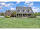 Inviting brick home with a columned front porch, attractive landscaping, and a lush green lawn at 6419 Gilead Rd, Huntersville, NC 28078