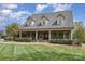 Charming brick home features a welcoming front porch with classic columns and meticulously kept landscaping at 6419 Gilead Rd, Huntersville, NC 28078