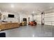 Spacious garage with epoxy floor, couch, zero turn lawn mower and shelving at 6419 Gilead Rd, Huntersville, NC 28078