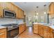 Well-equipped kitchen featuring stainless appliances, white subway tile, and custom oak cabinets at 6419 Gilead Rd, Huntersville, NC 28078