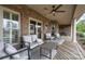 Cozy covered patio with brick columns, ceiling fan, seating and a wooden deck overlooking the backyard at 6419 Gilead Rd, Huntersville, NC 28078