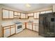 Clean kitchen featuring white appliances, wood-trimmed cabinets, and tile flooring, providing functionality and style at 700 Fine Wright Ave, York, SC 29745