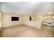 Open-concept living space flowing into kitchen, featuring neutral carpet, mounted television, and natural light at 700 Fine Wright Ave, York, SC 29745