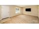 Bright living room with neutral carpet, large window, and a mounted television, with a view of the front yard at 700 Fine Wright Ave, York, SC 29745
