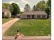 Well-manicured lawn surrounds this single-story home with a long driveway at 7428 Beaufort Cir, Charlotte, NC 28227