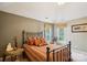Bedroom with large window, tan walls, and bronze metal bedframe at 7444 Hurstbourne Green Dr, Charlotte, NC 28277