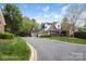 Long shot of a brick home with manicured landscaping and a curved driveway at 7444 Hurstbourne Green Dr, Charlotte, NC 28277