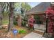 Brick home with a black wrought iron gate, mature landscaping, and secured by ADT at 7444 Hurstbourne Green Dr, Charlotte, NC 28277