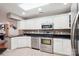 Updated kitchen with stainless appliances, white cabinets, and black countertops at 7444 Hurstbourne Green Dr, Charlotte, NC 28277