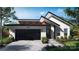 Modern home with a two-car garage, sleek black accents, and beautifully landscaped front yard at 8038 Pawtuckett Rd, Charlotte, NC 28214