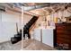 Unfinished basement with washer/dryer, exposed brick, and dark painted stairs leading to another level at 902 Hawthorne Rd, Shelby, NC 28150