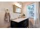 Bathroom features a marble countertop, a dark vanity, and a mirror with decorative lighting at 902 Hawthorne Rd, Shelby, NC 28150