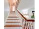 A staircase with white risers and wooden treads and banister, ascends to the upper level of the home at 902 Hawthorne Rd, Shelby, NC 28150