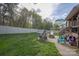 Backyard with a playhouse, a fire pit, an Adirondack chair set, and a lush green lawn at 908 Carole Summey Dr, Dallas, NC 28034
