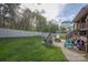 Large backyard with a playset, fire pit, and playhouse, with a patio area connected to the house at 908 Carole Summey Dr, Dallas, NC 28034
