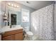 Bright bathroom with a single sink vanity and a colorful polka dot shower curtain at 908 Carole Summey Dr, Dallas, NC 28034