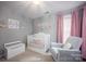 Charming Bedroom with white crib, comfortable chair, and soft pink accents creating a serene atmosphere at 908 Carole Summey Dr, Dallas, NC 28034