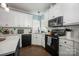 Modern kitchen with white cabinetry, black appliances, and stylish herringbone backsplash at 908 Carole Summey Dr, Dallas, NC 28034