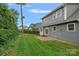Well-maintained backyard featuring a manicured lawn, quaint patio, and the home's exterior at 911 Naples Dr, Davidson, NC 28036