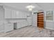 Bright basement with white cabinets, a sink, a refrigerator, and open shelving at 911 Naples Dr, Davidson, NC 28036