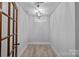 Finished basement with hardwood floors, and a chandelier, accessed by a dark stained glass door at 911 Naples Dr, Davidson, NC 28036