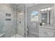 Elegant bathroom with a glass-enclosed shower featuring gray tile and modern fixtures at 911 Naples Dr, Davidson, NC 28036