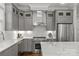 Close up of kitchen area featuring gray cabinets, stainless steel appliances, and marble countertops at 911 Naples Dr, Davidson, NC 28036