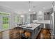 Bright kitchen features gray cabinets, an island with bar stools, stainless steel appliances, and hardwood floors at 911 Naples Dr, Davidson, NC 28036