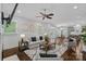 Cozy living room open to dining area, featuring neutral tones, hardwood floors, and a ceiling fan at 911 Naples Dr, Davidson, NC 28036