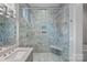 Glass enclosed shower with marble tile, rainfall shower head, and built-in bench at 911 Naples Dr, Davidson, NC 28036