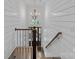 Bright stairway with white shiplap walls and wood railing with views to a front entry with beautiful front door at 911 Naples Dr, Davidson, NC 28036