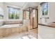 Luxurious bathroom with large soaking tub and glass enclosed shower with natural light at 9927 Clarkes View Nw Pl, Concord, NC 28027