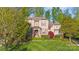 Charming home boasts manicured lawn, stone accents, and mature trees at 9927 Clarkes View Nw Pl, Concord, NC 28027