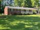 Charming, red brick, single-story home with well-maintained landscaping and a covered carport at 1014 Stuart Dr, Wadesboro, NC 28170