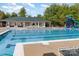 Community pool area with lounge chairs, a clubhouse, and a playground for residents at 10318 Caldwell Depot Rd, Cornelius, NC 28031