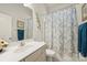 Well-lit bathroom with a vanity, toilet, and a shower-tub combination with a patterned curtain at 10378 Ambercrest Nw Ct, Huntersville, NC 28078