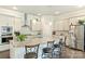 Bright kitchen with gray cabinets, granite counters, stainless appliances, island with bar seating, and hardwood floors at 10378 Ambercrest Nw Ct, Huntersville, NC 28078