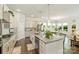 Bright kitchen with gray cabinets, granite counters, stainless appliances, island, and hardwood floors leading to the dining area at 10378 Ambercrest Nw Ct, Huntersville, NC 28078