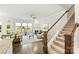 Bright living room with a fireplace, hardwood floors, natural light, and a staircase at 10378 Ambercrest Nw Ct, Huntersville, NC 28078