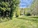 Exterior shot of a property with mature trees in a grassy meadow at 105 Branson Dr, Olin, NC 28660