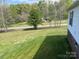 Exterior of home featuring green lawn, treeline and country road at 105 Branson Dr, Olin, NC 28660