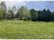 Wide shot of exterior featuring large green lawn with sparse trees and foliage at 105 Branson Dr, Olin, NC 28660