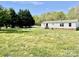 Exterior of home featuring large yard with mature trees and covered entrance at 105 Branson Dr, Olin, NC 28660