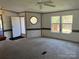 Bright living room with two windows, neutral carpet, ceiling fan, and entrance door at 105 Branson Dr, Olin, NC 28660
