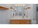 Bright bathroom featuring a large mirror with updated vanity and shelving, plus a shower/tub combination at 105 Sterling Ter, Mooresville, NC 28115