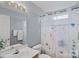 Well-lit bathroom featuring a large mirror, floral shower curtain, and a clean white vanity at 105 Sterling Ter, Mooresville, NC 28115