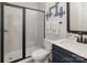 Modern bathroom featuring a glass shower, blue vanity, and unique wall decor for a stylish touch at 1077 Hearth Sw Ln, Concord, NC 28025