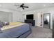 Bright bedroom featuring a ceiling fan, carpet flooring, and a gray accent wall with a TV at 1077 Hearth Sw Ln, Concord, NC 28025