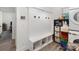 Mudroom with built-in bench, coat hooks, storage cubbies, and a nearby washer and dryer at 1077 Hearth Sw Ln, Concord, NC 28025