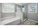 Bright bathroom showcasing a tub, glass-enclosed shower, and neutral tile at 1158 Waterford Dr, Hickory, NC 28602
